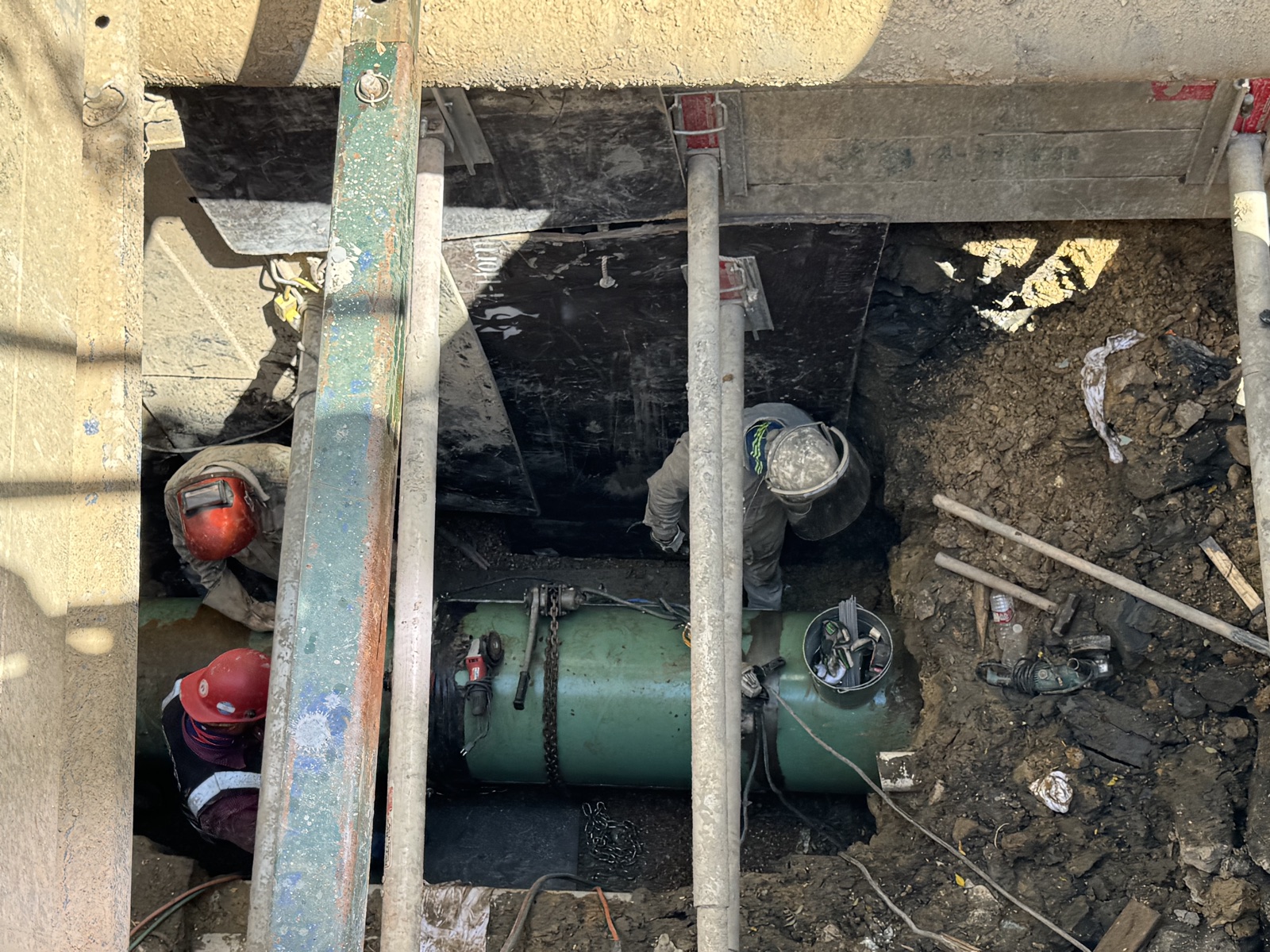 Utility pipeline leak investigation and clamshell casing repair in shored excavation