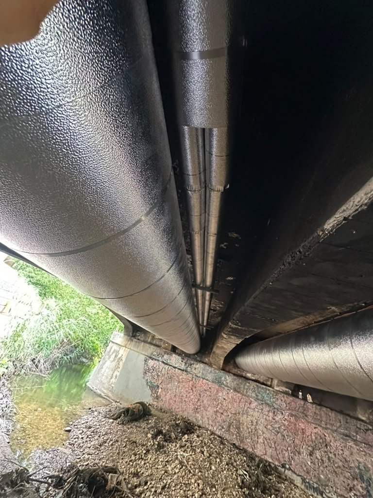 Shoal Creek Bridge chilled water infrastructure restoration with aluminum cladding and rigid conduit